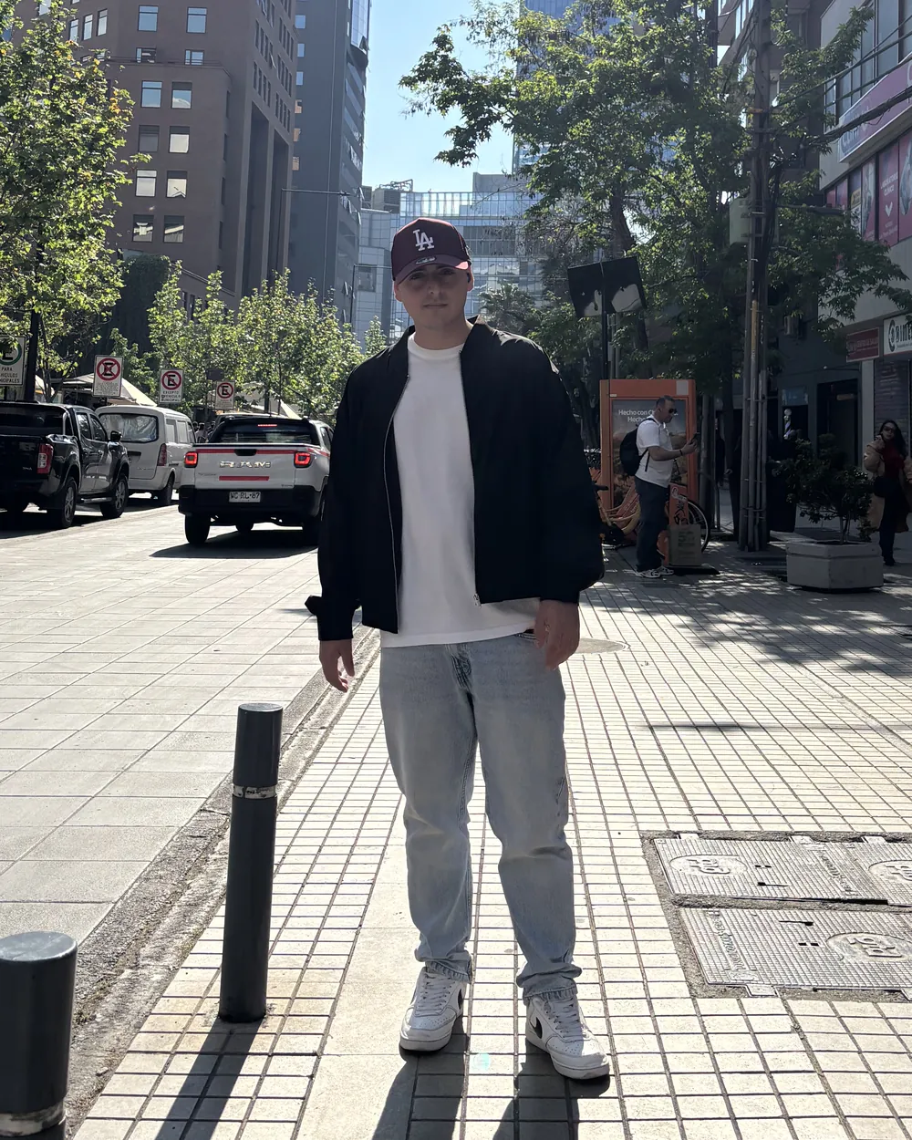 Mateo Plaza de pie en la calle, con un rascacielos detrás